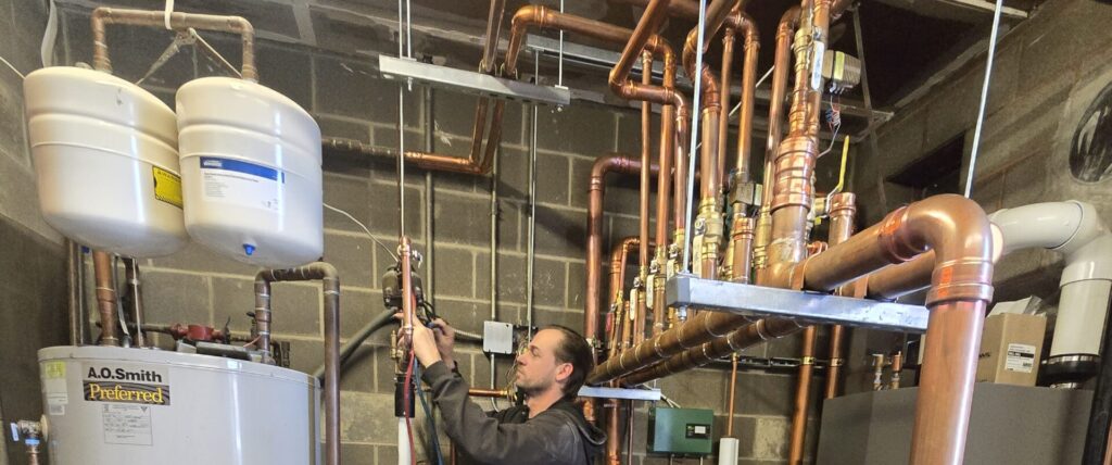 Technician performing annual backflow prevention test on commercial fire sprinkler system riser in Ohio